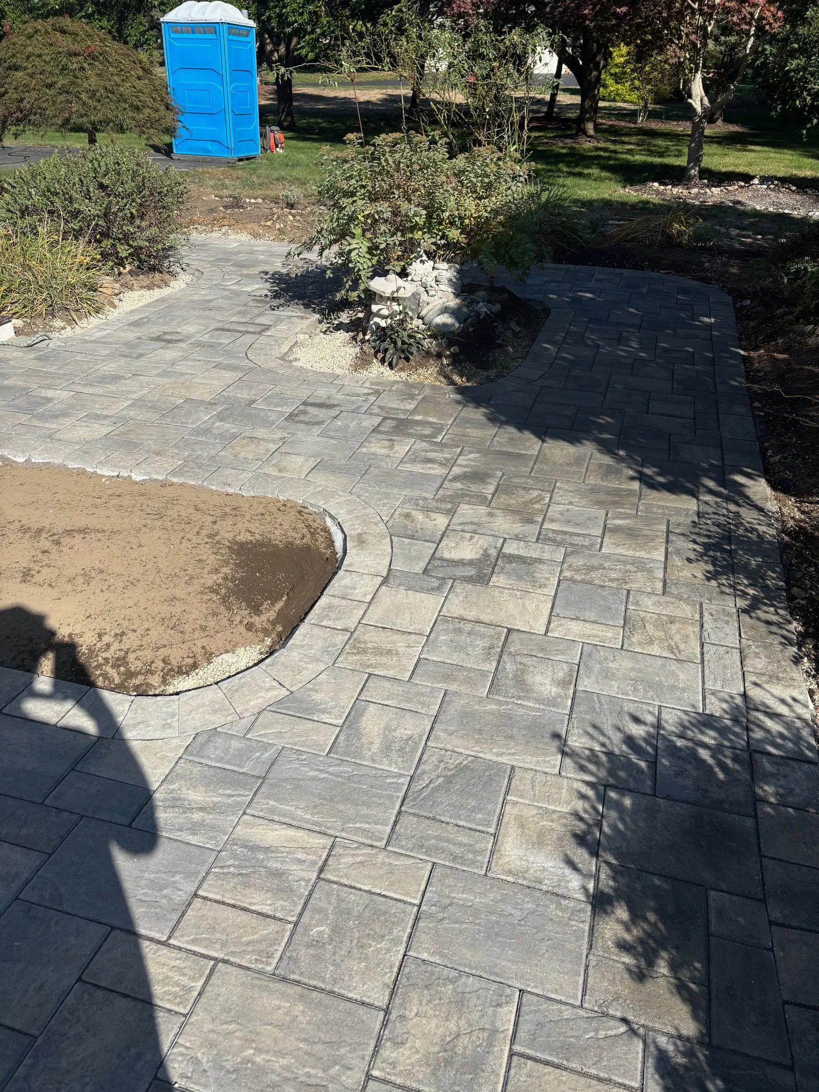 Curved paver patio and walkway during landscape construction