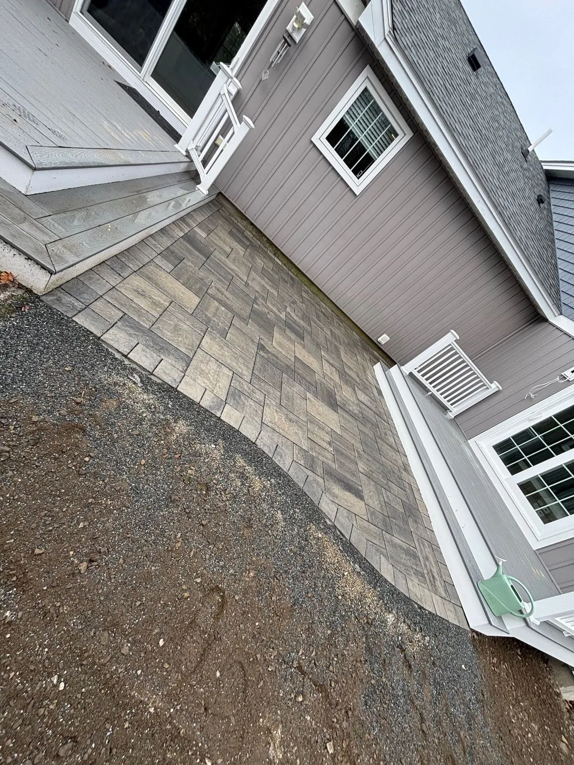 Paver patio running along the side of a house