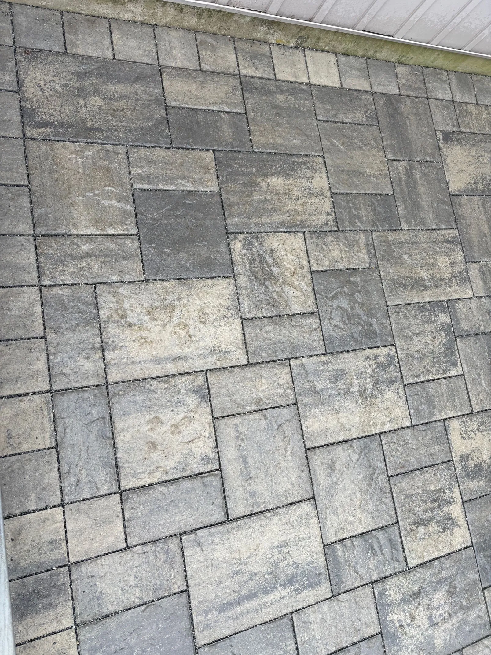 Close view of mixed gray pavers laid in a varied bond