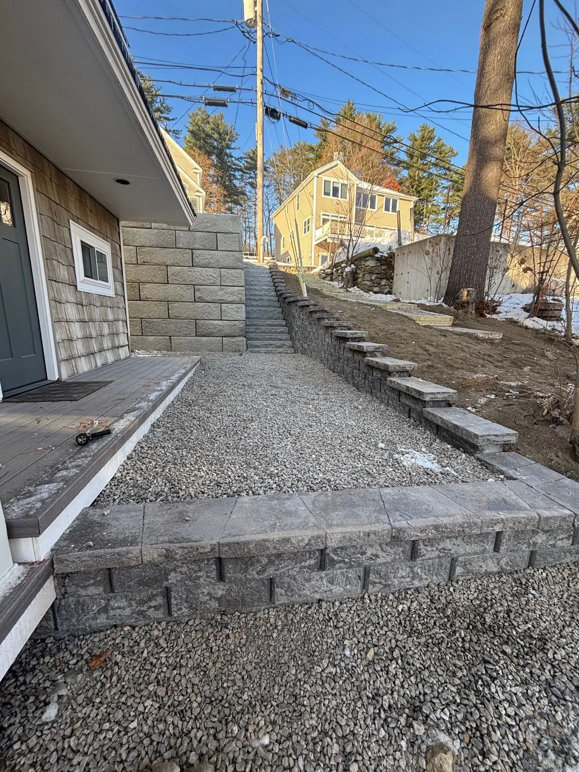 Retaining walls and steps managing a sloped residential grade